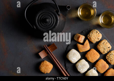 Mochi Sortiment mit Holz- chopticks und Tee traditionelle japanische Reis Dessert flach Top View Stockfoto