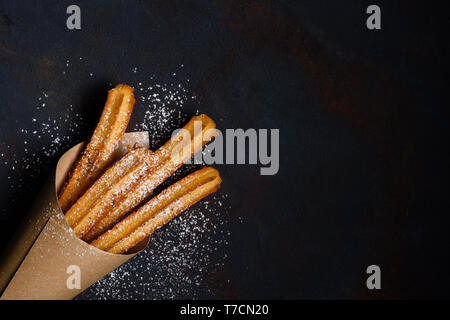 Churros Stöcke frischen heißen in Papiertüte auf dunklem Hintergrund mit Kopie Raum Stockfoto