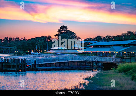 Orlando, Florida. April 23, 2019. Magic Kingdom Wharf und grünen Wald auf bunten Sonnenuntergang Hintergrund bei der Walt Disney World. Stockfoto