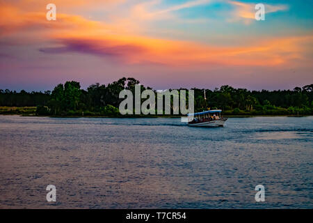 Orlando, Florida. 23. April 2019. Taxi Boot und grüne Wälder auf bunten Sonnenuntergang Hintergrund bei der Walt Disney World. Stockfoto