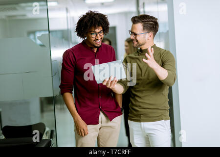 Jungen multiethnischen Geschäftspartner mit einem digitalen Tablet im Büro Stockfoto