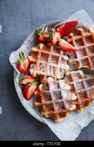 Frische Waffeln mit Zucker Zucker und Erdbeeren Stockfoto