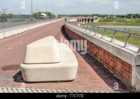 Nijmegen, Niederlande, 25. April 2019: Konkrete Bank, auf neue Stadt Brücke De Overstek mit Blick auf die Auen des Flusses Waal Stockfoto