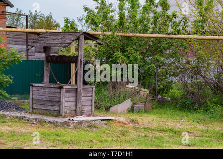 Alte hölzerne gut im Hinterhof in der Landschaft Stockfoto