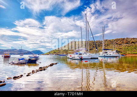 Yachten und Boote über das ruhige Meer bei gumsuluk Bucht in Bodrum, Mugla, Türkei verankert. Stockfoto