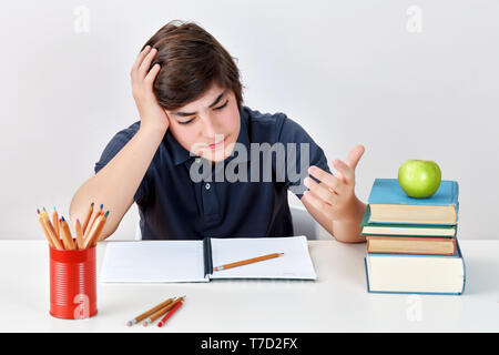 Secondary School junge Schüler mit ADHS ist Gefühl verwirrt und verärgert, während seine Hausaufgaben Stockfoto