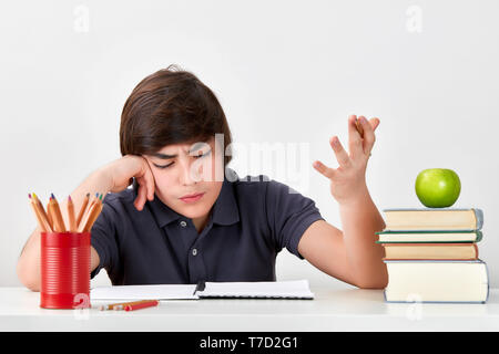 Secondary School junge Schüler mit ADHS ist Gefühl verwirrt und verärgert, während seine Hausaufgaben Stockfoto