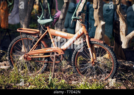 Bodrum, Türkei - Januar, 2019: Altes rostiges Fahrrad für Kinder als dekoratives Objekt in einem Garten verwendet. Editorial. Stockfoto