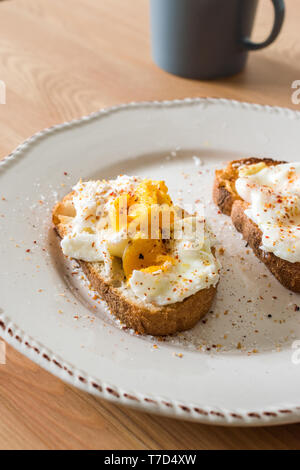 Hausgemachte pochierte Eier mit Gewürzen und Brot auf Holz- Oberfläche in der Regel serviert mit Kaffee bereit zu essen. Stockfoto