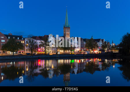 St. Petri Kirche/Petrikirche und historischen Häusern entlang der Trave in der Dämmerung in der Hansestadt Lübeck, Schleswig-Holstein, Deutschland Stockfoto