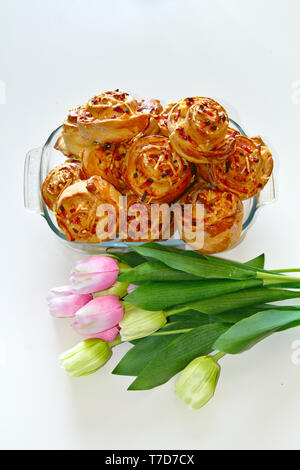 Weltbesten pinwheels mit köstlichen Schinken und Käse. Mit rosa und weißen Tulpen umgeben. Stockfoto