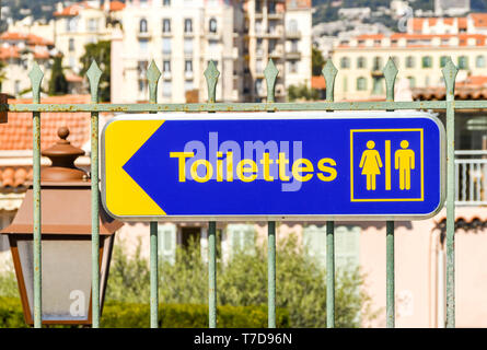 CANNES, Frankreich - April 2019: Schild zeigt die Richtung zu den männlichen und weiblichen Toiletten in Cannes. Stockfoto