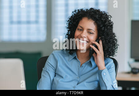 Reife Geschäftsfrau, Sitzen an Ihrem Schreibtisch im Gespräch am Mobiltelefon Stockfoto