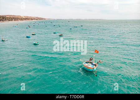 Traditionelle, runde Boote auf dem Meer, mit vietnamesischen Flagge, Mui Ne Vietnam Stockfoto