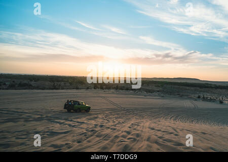 Wüstensafari mit Off Road 4x4 Auto im Sonnenlicht. bunten Sonnenuntergang in der Wüste. off-road Autofahrten auf dem Sand in der Wüste Dünen in den Strahlen der Risi Stockfoto