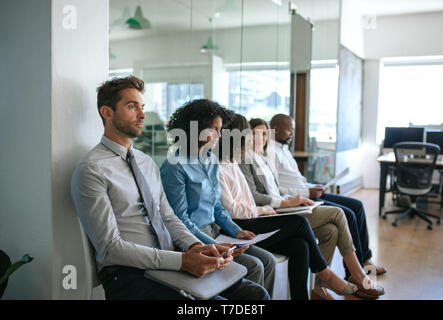 Gruppe von verschiedensten Menschen warten auf Interviews in einem Büro Stockfoto