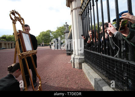 Menschen versammeln sich außerhalb der Buckingham Palace Bilder auf ihren Mobiltelefonen der Bekanntmachung auf einer Staffelei auf dem Vorplatz des Palastes in London zu nehmen, um die Geburt eines Jungen an den Herzog und die Herzogin von Sussex offiziell zu verkünden. Stockfoto