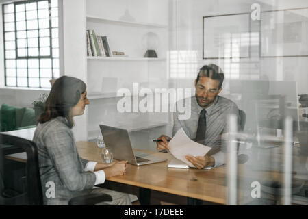 Lächelnd manager Lesen eines Bewerbers Lebenslauf in einem Interview Stockfoto