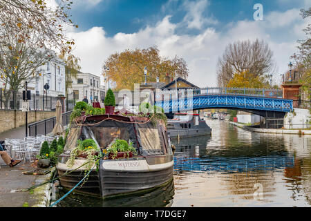 Ein Schmalboot vertäute bei Little Venice am Regent's Canal mit der blauen Westbourne Terrace Road Brücke im Hintergrund, London, Großbritannien Stockfoto