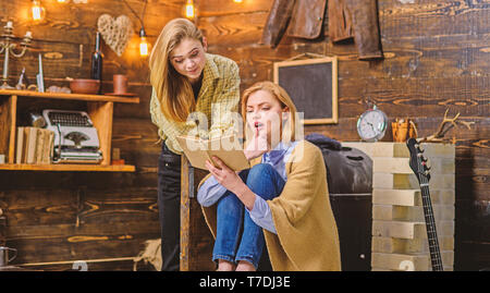 Mädchen über neue Arbeit von lieblingsautor aufgeregt, Literatur Diskussion club, Poesie der Nacht. Bücherwürmer, Mutter und Tochter, lesen faszinierendes Buch im Wohnzimmer von Holz- Haus auf dem Land. Stockfoto