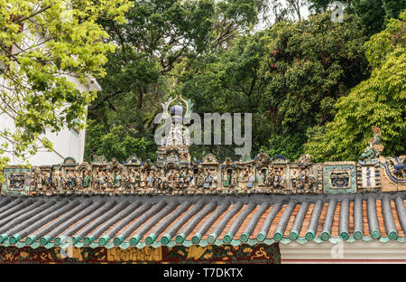 Hong Kong, China - 7. März 2019: das Fischerdorf Tai O. Umfangreiche statue Dekorationen auf dem Dach von Kwan Tai taoistische Tempel. Von grünen Pflanzen umgeben ist. Stockfoto