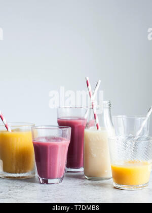 Smoothies in nicht zusammenpassende Gläser und Flaschen mit Papier Trinkhalme Stockfoto