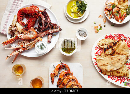 Tablescape mit Platten mit frischen Meeresfrüchten und Fladenbrot Stockfoto