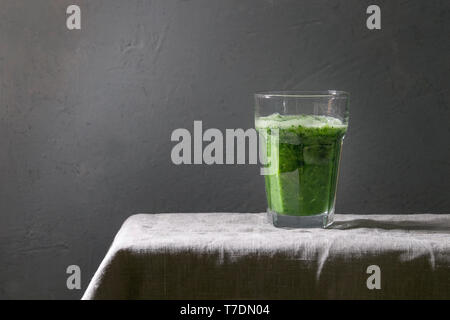 Grüne Spinat kale apple Smoothie in Glas auf Leinen Tischdecke. Gesunde organische Essen. Stockfoto