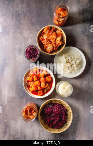 Vielzahl von fermentierter Lebensmittel traditionellen koreanischen Kimchi Kohl und Rettich Salat, Weiß und Rot, Sauerkraut in Glas und keramische Platten über grauer Text Stockfoto