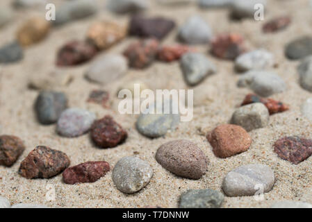 Spiralförmige Muster aus pebbes auf Sand Hintergrund Stockfoto