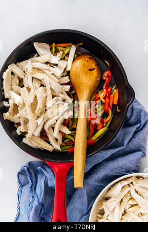 Geschnittene Austernpilze, Zwiebeln, rote und grüne Paprika sauteed in einer gusseisernen Pfanne. Stockfoto