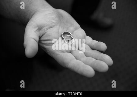 Mann hält Hochzeit Ringe in der Handfläche Stockfoto