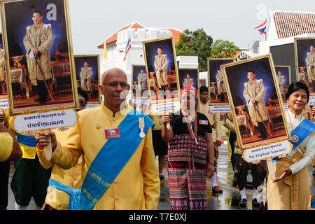 Gratulanten gesehen Holding Porträts von Thailands König Rama X während eines Elefanten Royal Parade (nicht abgebildet) Thailands König Maha Vajiralongkorn Bodindradebayavarangkun Krönung in Bangkok zu feiern. Stockfoto