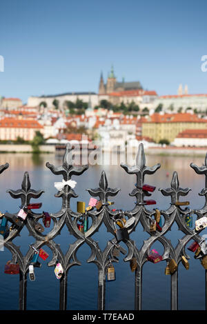 Vorhängeschlösser auf der Karlsbrücke in Prag mit der Kathedrale hinter Stockfoto