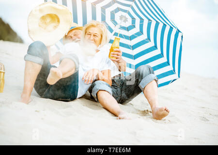 Gerne älteres Paar Spaß, Spielen mit Sand am Strand, ihren Ruhestand in der Nähe des Meeres genießen. Stockfoto