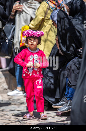 Niasar, Iran, 25. April 2019: iranische Mädchen mit Blumen auf dem Kopf in einer Wolke Stockfoto