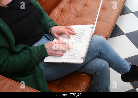 Frau mit Laptop auf der Couch home Stockfoto
