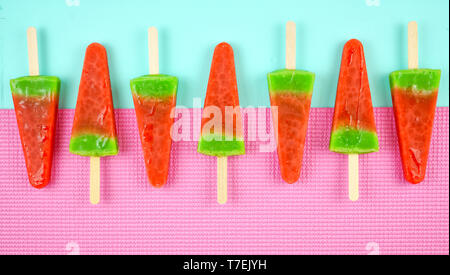 Wassermelone aromatisiert Sommer Thema Eis Eis am Stiel auf Rosa und blauem Hintergrund. Stockfoto