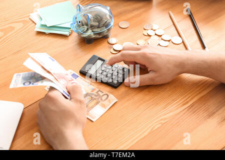 Junger Mann zählen Geld am Tisch, Nahaufnahme Stockfoto