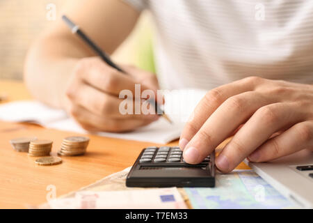 Junger Mann zählen Geld am Tisch, Nahaufnahme Stockfoto