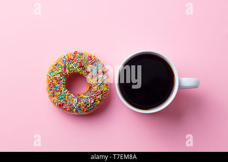 Kaffee mit Donut auf rosa Papier Hintergrund. Ansicht von oben. Kopieren Sie Platz. Stockfoto
