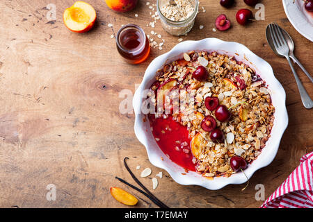 Pfirsich und Berry in einer Auflaufform bröckeln. Ansicht von oben. Kopieren Sie Platz. Stockfoto