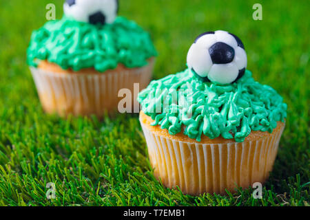 Fußball-Party, Geburtstag Cupcake auf grünem Gras Hintergrund eingerichtet. Close Up. Stockfoto