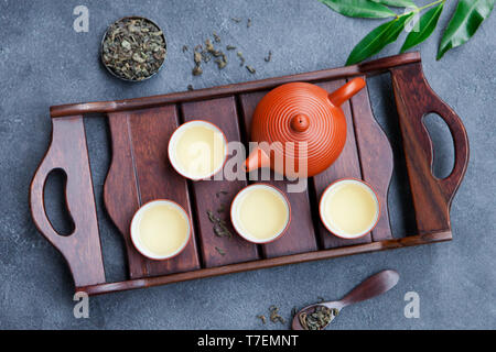 Grüner Tee, Teekanne und Schüsseln, Tassen auf schiefer Hintergrund. Ansicht von oben. Stockfoto