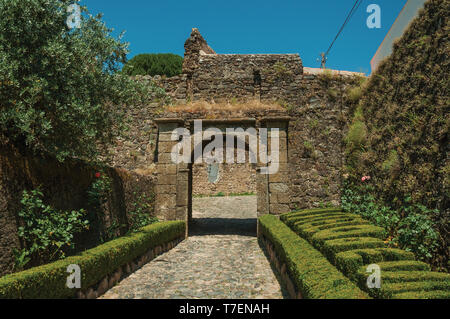 Gepflasterten Weg, dem Gateway in Steinmauer mit Garten in Castelo de Vide. Schöne Stadt mit mittelalterlichen Burg an den Portugal Ostgrenze. Stockfoto