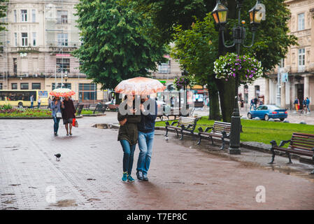 Lemberg, Ukraine - Juni 14, 2018: die Menschen zu Fuß im Quadrat mit Regenschirm. regnerische Wetter Stockfoto