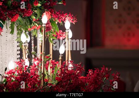 LED-Leuchte in der Gold Kerze, die in der Hochzeit Veranstaltung mit Rote Orchidee um. Stockfoto