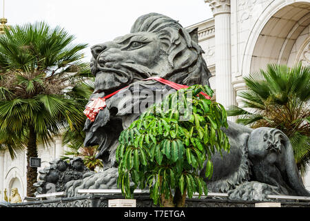 Bis big black lion Statue mit roten Schal sitzen vor Gebäude schließen., Laos. Stockfoto