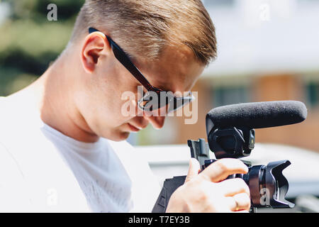 Kameramann mit Kamera auf einem mono-pod am Schießen Stockfoto