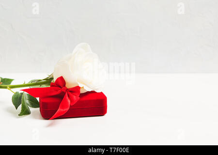 Weiße Rose und roter Geschenkbox für Schmuck mit weißen strukturierten Hintergrund mit kopieren. Selektive konzentrieren. Mock up. Valentinstag Konzept Stockfoto